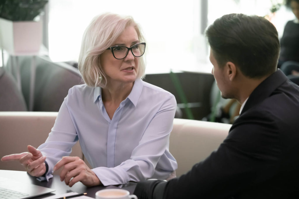 Older woman having a discussion with a younger man.