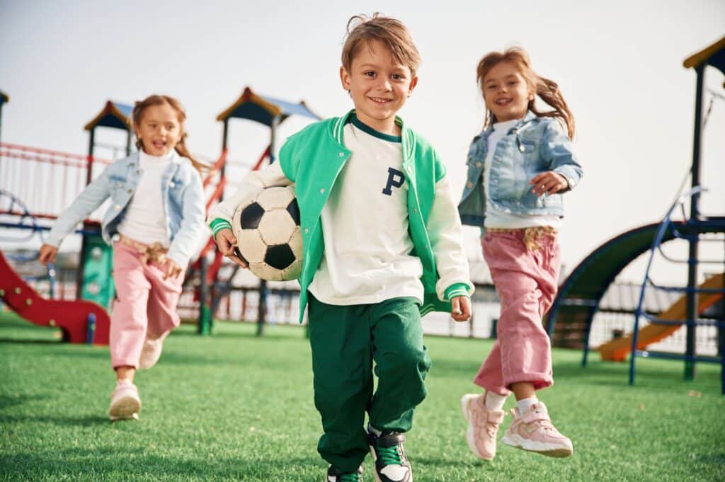 Kids playing outside for recess with a soccer ball.