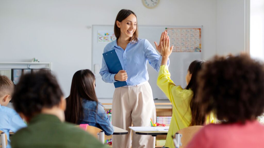 A cheerful teacher high-fives one of her students.