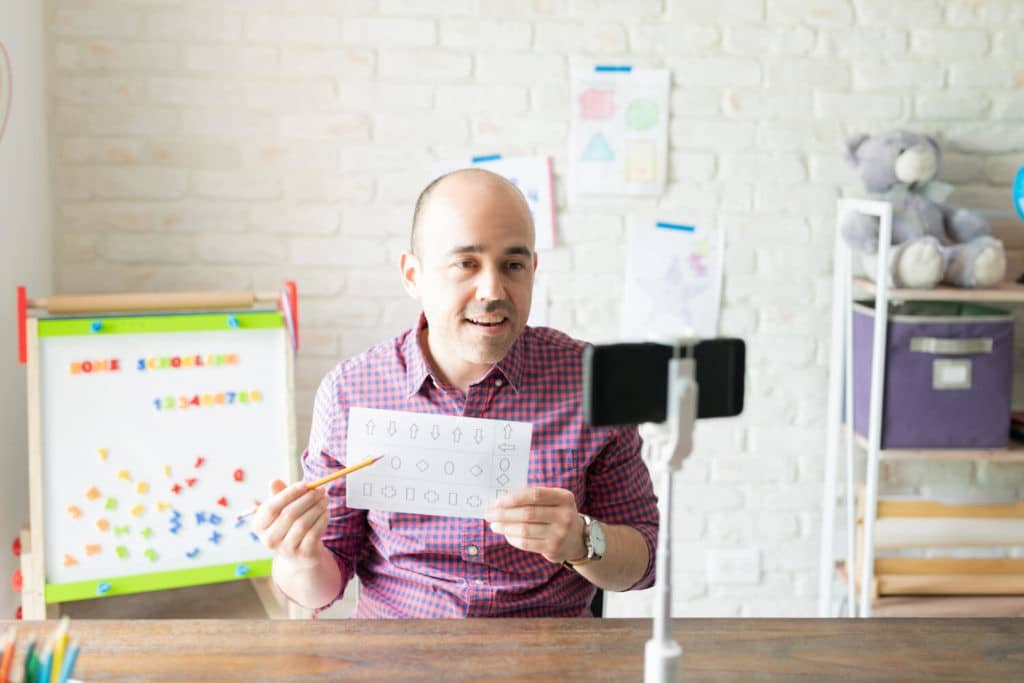 Teacher instructing his class while on camera.