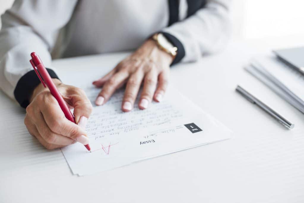 A teacher grades an essay, marking it with an “A” grade.