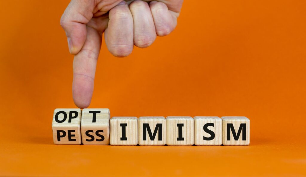 A row of cubes spell out the word “optimism.”