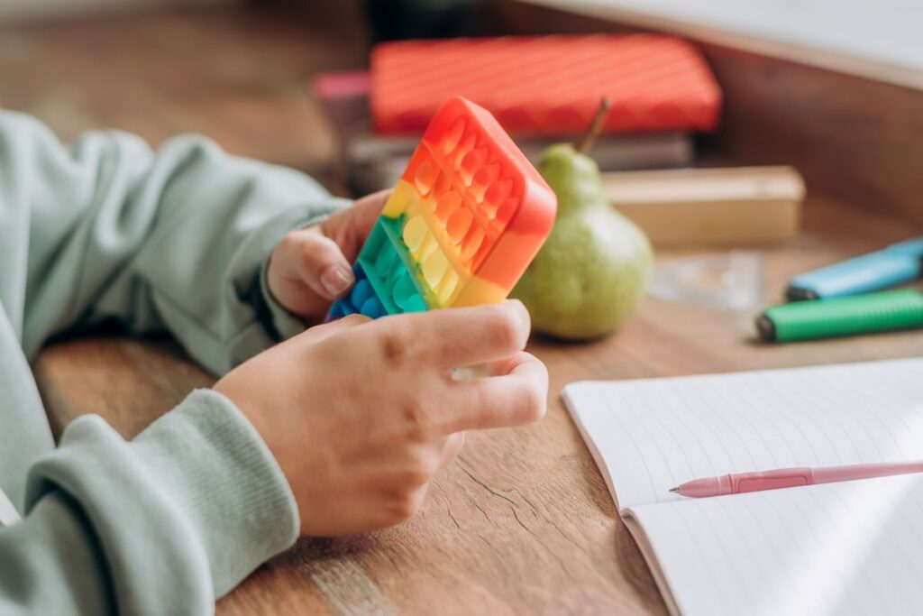 A student plays with a colorful pop-it fidget toy.